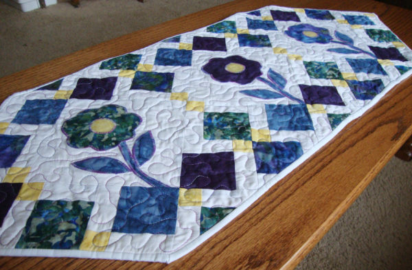 "Spring Flowers" is a Free Spring Quilted Table Runner Pattern designed by Stephanie De Pasquale-Soebbing from Quilt Addicts Anonymous!